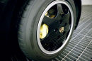 Repainted & conditioned black alloy wheels with clear rims on 944 s2 convertible, plus yellow Porsche calipers.